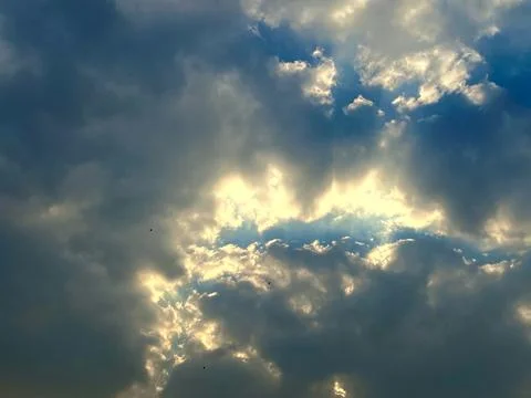 Golden Sunbeams Breaking Through Dramatic Clouds in a Scenic Blue Sky View Stock-Fotos