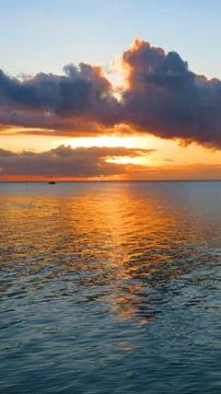 Golden Sunburst Between Storm Clouds Over Calm Sea Fotos Stock