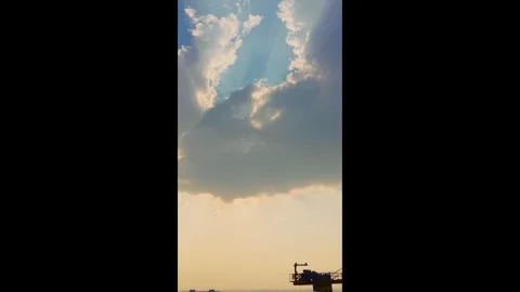 Golden Sunlight Beaming Through White Clouds in a Clear Blue Sky at Sunset Stock Footage 339912423