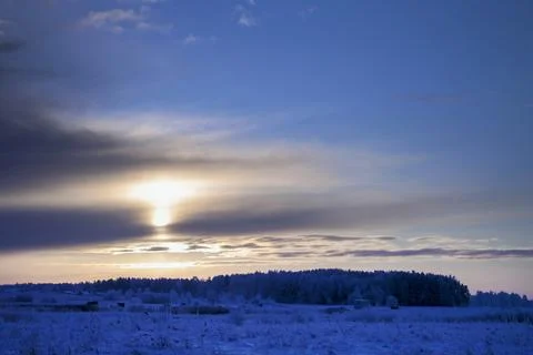 Golden Sunlight Breaking Through Clouds Over Winter Landscape Foto stock