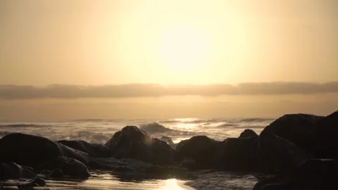 Golden sunlight cascading over tranquil ocean waves at sunrise Stock Footage 293157941
