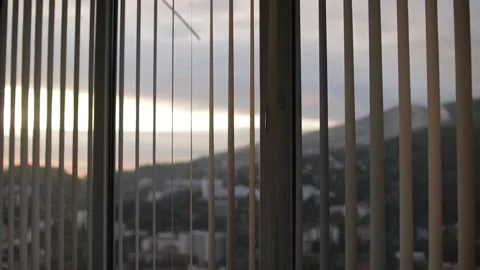Golden sunlight filtering through window blinds, casting soft shadows across Stock Footage 308878843