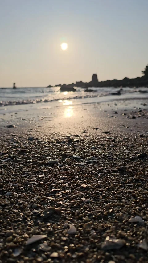 Golden Sunlight Over Pebbled Beach at Low Angle, Soft Ocean Waves, 4K Vídeos de archivo 330035569