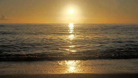 Golden sunset on a beach - slow motion of foamy waves rolling towards white sand Video stock 229804615