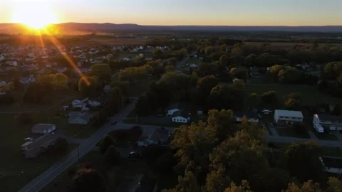 Golden sunset behind mountains of idyllic suburb neighborhood in USA. Aerial Stock Footage 320870514