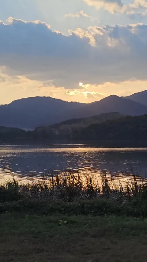 Golden Sunset Behind Mountains Reflecting on Calm River in Korea Vídeos de archivo 330175340