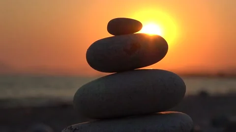 Golden sunset behind piled pebbles Stock Footage 137358121
