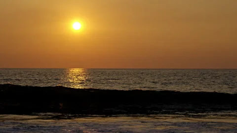 A golden sunset with a big wave hitting the beach Stock Footage 264942559