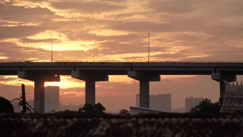 A golden sunset casts a warm glow over an urban bridge Видео 320808546