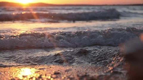 Golden sunset illuminating ocean waves crashing onto a rocky shore. Stock Footage 342439400