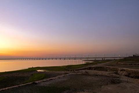 Golden Sunset at Jamuna River with Illuminated Jamuna Bridge at Tangail. Stock Photos