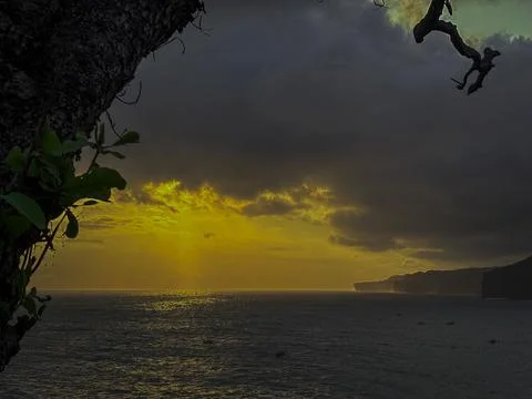 Golden Sunset Light Breaking Through Clouds Above Ocean Horizon Stock Photos
