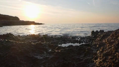 Golden sunset light glows brightly across rocky coastal ocean waters. Stock Footage 337413485
