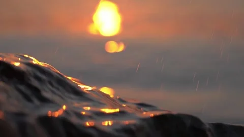 Golden sunset light illuminates ocean wave crest and water spray Stock Footage 337410794