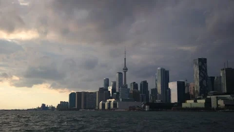 Golden sunset light illuminating dark storm clouds over the Toronto skyline Stock Footage 296603279