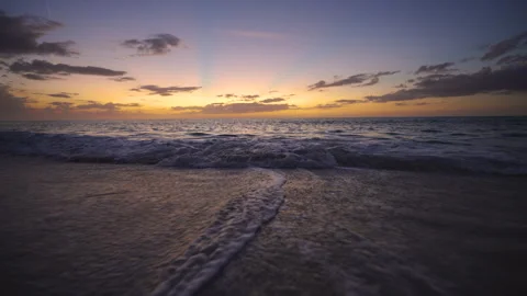 Golden sunset light over shoreline with splashing waves and glowing sky Stock Footage 333699337
