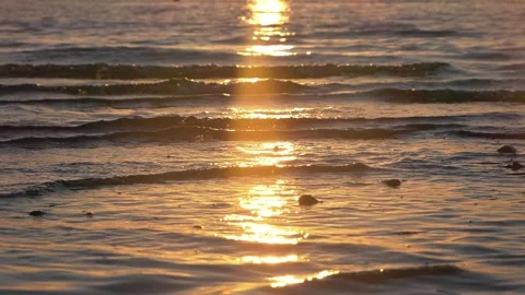 Golden sunset light reflecting brightly across gentle ocean wave ripples. Stock Footage 337408687