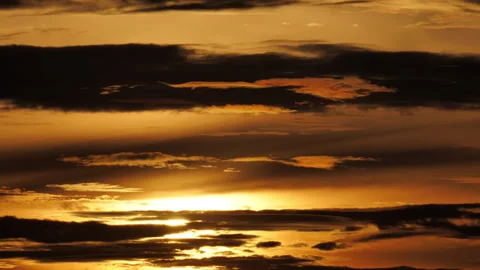 Golden sunset light shifting behind stratified silhouetted layers, time-lapse Stock Footage 346162411