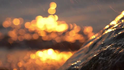 Golden sunset light shimmers brightly over ocean water and rocks. Stock Footage 337406924