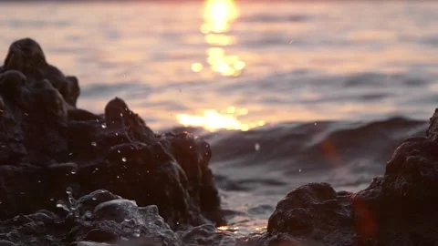 Golden sunset light shimmers over ocean waves and rocky shores. Stock Footage 337406754