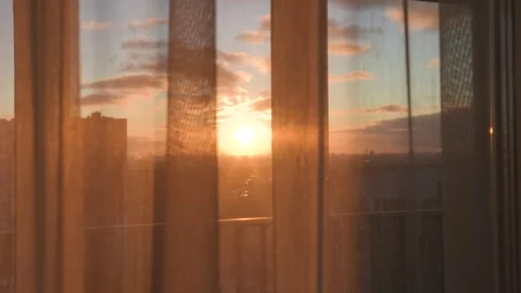 Golden sunset light shining through sheer curtains on window Stock Footage 325670836