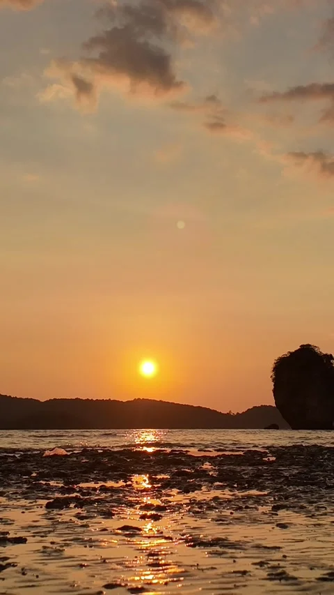 Golden sunset with limestone mountains and calm ocean waves. Stock Footage 334568828