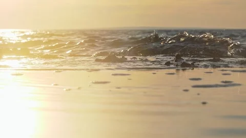 Golden Sunset Ocean Waves Lapping A Sandy Beach With Reflective Wet Shoreline Stock Footage 337306675
