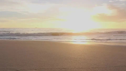 Golden sunset over the beach as waves roll in 스톡 동영상 160124925