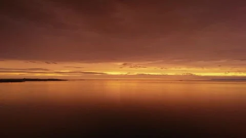 Golden sunset over calm ocean waters with dramatic twilight sky Stock Footage 342201803