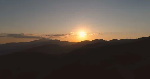 Golden sunset over dark mountain peaks silhouettes Stock Footage 129837104