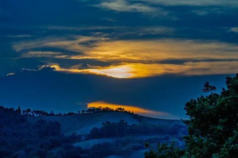 Golden sunset over Marche Romagna hills with dramatic clouds Stock Photos