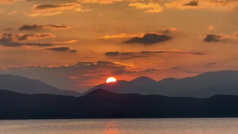 Golden sunset over mountain range and calm lake Vídeos de archivo 334085038