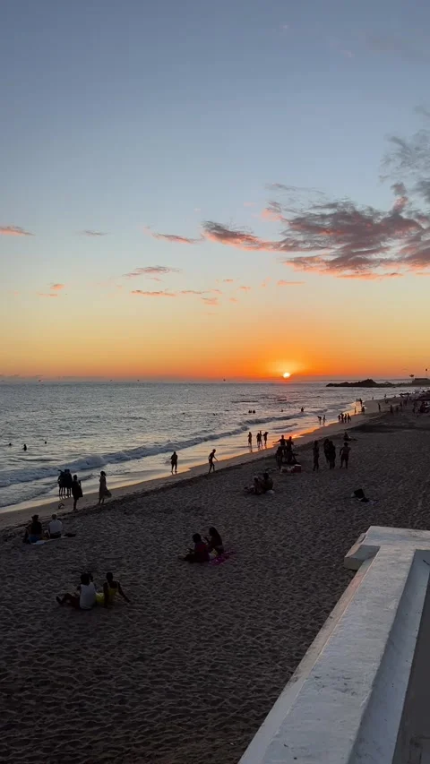 Golden Sunset over Ocean Beach with People Relaxing on Sand Tropical View Vidéo 343779989