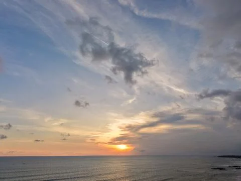 Golden sunset over the ocean with dramatic cloudy sky Stock Photos