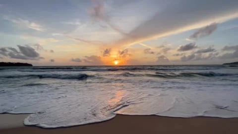 Golden sunset over ocean waves with glowing reflections on sandy beach horizon Stock Footage 316669332