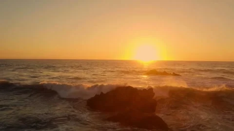Golden Sunset Over Ocean Waves with Silhouetted Sea Rock Stock Footage 319999101