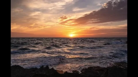 Golden sunset over ocean waves hitting rocky coastline Stock Footage 334807278