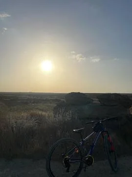 Golden Sunset Over Open Fields in Ayios Nikolaos, Cyprus, with a Bicycle Re.. Stock Photos