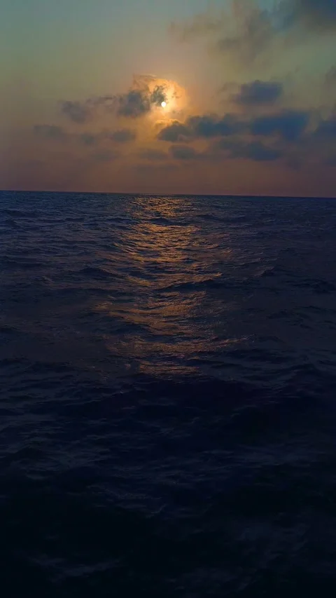 Golden sunset over the open ocean with dramatic clouds and gentle waves Stock-Footage 341111232