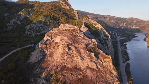 Golden Sunset Over Riverside Bridge with Ancient Cliff Tomb Vídeo Stock 337349530