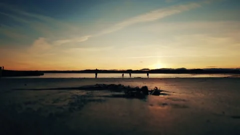 Golden sunset over sandy beach with people in silhouette stock footage Vídeos de archivo 313522402