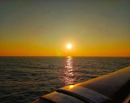 Golden Sunset Over the Sea with Dramatic Sky and Calm Water Stock Photos