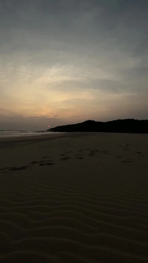 Golden Sunset Over Vast Sandy Beach and Ocean, Hills Silhouette, Vertical Pan Stock Footage 324770688