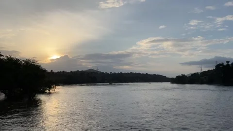 Golden Sunset Over Wide River with Scenic Mountain Silhouette and Sky Stock Footage 342546516