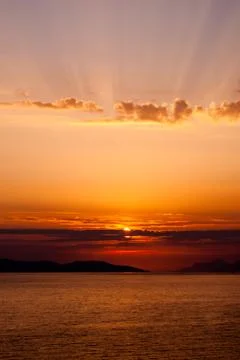 Golden sunset with rays above clouds, sun covered by cloud Stock Photos