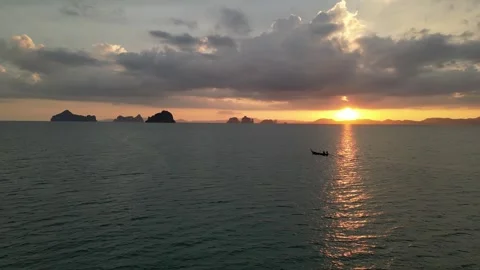 Golden Sunset Reflecting on the Ocean with a Longtail Boat in Krabi, Thailand Stock Footage 335255952