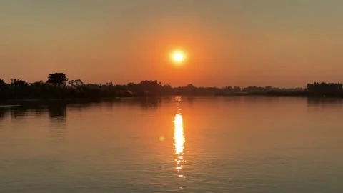 Golden sunset reflecting on a tranquil river surface creating a peaceful an.. Stock Footage 321714662