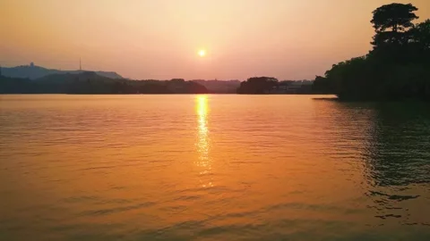 Golden sunset reflection on calm lake water in a natural landscape 스톡 동영상 342003404