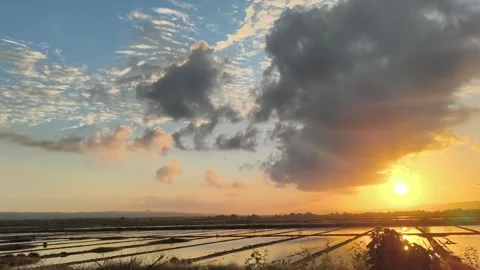 Golden Sunset Reflection on Flooded Salt Pans with Dramatic Clouds Stock Footage 340465254