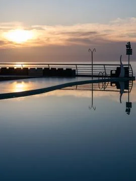 Golden Sunset Reflection in Luxury Infinity Pool. Stock Photos